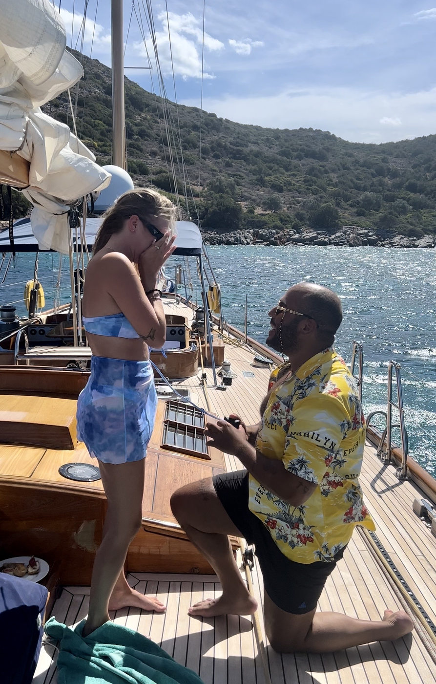 David on one knee proposing to Caro on a sailboat in Crete, September 2022